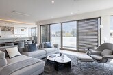 Located in the desirable Westwood neighborhood of Los Angeles, this single-floor residence at 1644 Malcolm Ave showcases a refined modern aesthetic throughout. Light hardwood flooring flows seamlessly across the open-concept living and dining areas, where subtle striped wallcoverings add texture and warmth. The dining space centers around an elegant oval walnut table beneath stylish globe pendant lights, opening directly to a chef's kitchen appointed with high-gloss white cabinetry, a striking marble slab backsplash, quartz countertops, and premium stainless steel appliances including a professional-grade range and French door refrigerator. A media room with a large wall-mounted display and cozy seating provides a dedicated entertainment retreat. The primary bedroom suite features curated abstract artwork, recessed lighting, and a generous walk-in closet with custom shelving and hanging systems. Its en-suite bath is a spa-like sanctuary showcasing floor-to-ceiling marble wall cladding, a freestanding soaking tub with ambient cove lighting, and a glass-enclosed shower. Additional bedrooms are bright and well-proportioned with ample closet space and natural light. A dedicated laundry room rounds out the home with full-size washer and dryer units, a utility sink, and abundant built-in cabinetry.