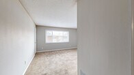 This well-designed single-story residence offers 990 square feet of comfortable living space. The home features three bedrooms, including a spacious primary bedroom of 210 square feet, and two full bathrooms. The updated kitchen showcases dark wood cabinetry, granite-like countertops, and modern black appliances, complemented by warm wood-look flooring. Large windows throughout allow ample natural light, enhancing the neutral color palette. Bedrooms are carpeted for comfort and include generous closet space. Bathrooms are equipped with modern vanities and fixtures, with at least one featuring a shower/tub combination. The open floor plan creates a seamless flow between living areas, ideal for both daily life and entertaining. Located in Atlanta, this home combines contemporary updates with practical living spaces, making it an attractive option for various lifestyles.