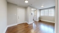 Located at 2000-2006 W Fargo Ave in Chicago's Rogers Park neighborhood, this two-bedroom, one-bathroom unit offers a well-organized single-floor layout designed for comfortable everyday living. Rich hardwood floors flow consistently throughout the space, complemented by neutral gray-toned walls, crisp white trim, and crown molding that lend a clean, classic character to each room.

The open entry area connects seamlessly to the kitchen, which features white cabinetry and a stainless steel refrigerator visible through an arched passageway. The living and entry areas are brightened by natural light from windows fitted with white horizontal blinds. A cast-iron radiator in the main living space adds a charming, period-appropriate detail.

Both bedrooms are well-proportioned and share the same warm hardwood floors and soft neutral palette. The primary bedroom includes a built-in arched niche with shelving, offering a distinctive architectural accent alongside a large window that fills the room with natural light. The second bedroom also features a cast-iron radiator and generous window. A hallway connects the bedrooms to the full bathroom, which is finished with white tile surround, a soaking tub with shower, and a glass block window that provides privacy while allowing diffused natural light. Six-panel white doors are used throughout, adding to the unit's cohesive, tidy aesthetic.