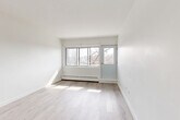 Located at 1150 Boul de la Côte-Vertu in the Saint-Laurent borough of Montréal, this well-appointed one-bedroom, one-bathroom unit offers a clean, modern aesthetic defined by bright white walls and light-toned hardwood flooring throughout the main living areas. Large windows flood the living room with natural light, while a glass door provides access to an outdoor balcony with open views of the surrounding neighbourhood. The layout flows naturally from the entryway — which features multiple closets for ample storage — through to the open living spaces. The kitchen is thoughtfully updated, showcasing white shaker-style cabinetry, marble-look tile flooring, a subway tile backsplash with a veined marble finish, stone-look countertops, and stainless steel appliances including a dishwasher and range. The bedroom is a comfortable, well-lit retreat with its own closet and large windows that invite generous daylight. The bathroom is finished in a neutral palette with a white vanity, gold-toned hardware, and terrazzo-style tile flooring, lending a clean and timeless feel. Baseboard heating is present throughout, and the overall ambiance of the unit is bright, airy, and move-in ready.