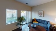 This single-floor residence offers a thoughtfully designed layout that balances functionality and comfort. The kitchen stands out with its crisp white shaker cabinetry, dark quartz countertops, and a full suite of stainless steel appliances, including a refrigerator, electric range, and built-in microwave. Track lighting and pendant fixtures illuminate the space, while wood-look flooring adds warmth and continuity.

The living area is bright and welcoming, featuring large windows and a sliding glass door that opens onto a private balcony, inviting natural light and outdoor views. The space flows naturally from the kitchen, creating an open and connected common area.

The primary bedroom is generously sized, featuring plush carpeting, neutral taupe walls, and a walk-in closet. A secondary bedroom offers similar finishes with a window overlooking a landscaped outdoor area. The bathroom is clean and well-appointed, with a white vanity, framed mirror, a lighted fixture above, and wood-look tile flooring that ties cohesively to the rest of the unit. Overall, the space maintains a modern, neutral aesthetic throughout.