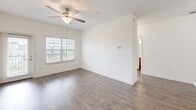 Located at Treviso Grand in Venice, FL, this 2-bedroom, 2-bathroom residence offers a well-designed, single-floor layout with a bright and clean aesthetic throughout. The open-concept living, dining, and kitchen area forms the heart of the home, featuring durable wood-style flooring, crisp white walls, and a ceiling fan that enhances airflow and comfort. Pendant lighting illuminates a kitchen peninsula with a light countertop and double sink, ideal for casual dining or meal prep. The kitchen is equipped with rich espresso-toned cabinetry, light countertops, and a full suite of stainless steel appliances, including a range, over-the-range microwave, dishwasher, and refrigerator, along with a dedicated pantry for added storage. Both bedrooms are carpeted and filled with natural light through sizable windows with blinds, each outfitted with a ceiling fan and closet space. The primary bedroom includes its own en-suite bathroom featuring a walk-in tile shower with built-in shelving. The secondary bathroom offers a full soaking tub and shower combo. Additional highlights include in-unit laundry and a private balcony, completing this functional and well-appointed residence.