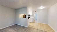 Located at 638 S Brampton Way in Salt Lake City, Utah, this single-floor unit offers a well-organized layout with a neutral color palette and updated finishes throughout. The living area features wood-look laminate flooring and is bathed in natural light from a front-facing window and glass-paneled entry door, creating a bright and welcoming atmosphere. A pass-through window connects the living space to the kitchen, adding an open, communicative feel between the two areas.

The kitchen is efficiently designed with white shaker-style cabinetry, white countertops, and light tile flooring. It is equipped with black appliances, including a refrigerator and electric range, alongside a stainless steel microwave. A single-basin sink is positioned along the countertop, maximizing workspace.

The bedroom offers wood-look flooring, a ceiling fan with a light fixture, and a window with blinds for natural light and ventilation. Notably, two sets of double bi-fold closet doors provide generous storage directly within the room.

The bathroom features light tile flooring, a wide vanity with white countertops, and a well-lit mirror. A hallway connects the main rooms, maintaining a logical and practical flow throughout the unit. Overall, the space presents a clean, updated, and functional living environment.