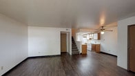 This two-story, 2-bedroom, 2-bathroom residence offers a well-organized layout designed for comfortable everyday living. The main level features an open living and dining area finished with dark hardwood-style flooring that extends throughout. A ceiling fan overhead adds airflow and a functional touch to the space. The kitchen is positioned adjacent to the living area and includes warm wood cabinetry, white appliances, and under-cabinet lighting, creating a practical cooking environment. A carpeted staircase leads to the upper level.

A standout feature of the lower level is the tile-surround fireplace in the living room, which serves as a natural focal point. A sliding glass door allows natural light to fill the room and provides outdoor access. The upper level houses both bedrooms, each carpeted and bright with natural light streaming through windows. One bedroom features dual corner windows, while the other offers a larger single window with outdoor views.

Both bathrooms are clean and functional, each equipped with a tub-shower combination, a vanity with a large mirror, and standard fixtures. The overall aesthetic is neutral and move-in ready, with a straightforward, practical design throughout both floors.
