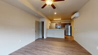 This single-floor unit at 4136 West Dunkirk Avenue in Hayden, Idaho offers a thoughtfully designed open-concept layout that connects the living area and kitchen seamlessly. The main living space features durable wood-look hard-surface flooring, neutral-toned walls, a ceiling fan with light fixture, and a ductless mini-split system for efficient year-round climate control. A large window allows natural light to fill the room while providing views of the surrounding exterior.

The kitchen is outfitted with rich, dark-stained wood cabinetry, stone-look countertops, and a full suite of stainless steel appliances, including a refrigerator, electric range, over-the-range microwave, and dishwasher. A peninsula counter provides additional workspace and separates the kitchen from the living area.

The bedroom is carpeted for added comfort and includes a closet along with a window that brings in natural light. The bathroom features a single-sink vanity with stone-look countertops, dark cabinetry, a large mirror, and a shower-tub combination with wood-look flooring continuing throughout. A dedicated in-unit laundry area accommodates a full-size washer and dryer with overhead shelving for additional storage.