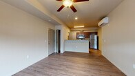 This single-floor unit at 4136 West Dunkirk Avenue in Hayden, Idaho offers a thoughtfully designed open-concept layout that connects the living area and kitchen seamlessly. The main living space features durable wood-look hard-surface flooring, neutral-toned walls, a ceiling fan with light fixture, and a ductless mini-split system for efficient year-round climate control. A large window allows natural light to fill the room while providing views of the surrounding exterior.

The kitchen is outfitted with rich, dark-stained wood cabinetry, stone-look countertops, and a full suite of stainless steel appliances, including a refrigerator, electric range, over-the-range microwave, and dishwasher. A peninsula counter provides additional workspace and separates the kitchen from the living area.

The bedroom is carpeted for added comfort and includes a closet along with a window that brings in natural light. The bathroom features a single-sink vanity with stone-look countertops, dark cabinetry, a large mirror, and a shower-tub combination with wood-look flooring continuing throughout. A dedicated in-unit laundry area accommodates a full-size washer and dryer with overhead shelving for additional storage.