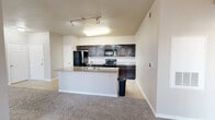 This single-floor residence offers a thoughtfully designed layout that maximizes functionality and comfort. The open-concept living, dining, and kitchen area serves as the heart of the home, featuring plush carpeting in the living zone and tile flooring in the kitchen. The kitchen is equipped with dark espresso cabinetry, granite-style countertops, a center island with a built-in sink, and a full suite of black appliances including a refrigerator, range, and over-the-range microwave. Track lighting overhead adds a modern touch to the space.

The spacious primary bedroom is finished with soft carpeting, a ceiling fan with light fixture, crown molding, and a window that allows natural light to fill the room. The bedroom is complemented by a walk-in closet outfitted with wire shelving and ample hanging space. A total of four closets throughout the unit provides exceptional storage capacity.

Both bathrooms feature consistent finishes, including dark cabinetry vanities topped with granite-style countertops, tile flooring, and a tub-shower combination. A hallway connects the private areas of the home, maintaining a clean and organized flow. Neutral tones and consistent finishes throughout create a cohesive, move-in-ready ambiance.