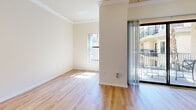 Located at 550 N Figueroa in the heart of Downtown Los Angeles, this efficiently designed single-floor unit offers a smart, functional layout across its combined kitchen and living space, plus a full bathroom. The living area is bright and airy, finished with warm light hardwood flooring and elegant crown molding. Large sliding glass doors open directly onto a private balcony, inviting natural light deep into the space and providing pleasant outdoor views of the surrounding neighborhood. A secondary window further enhances the sense of openness and ventilation.

The kitchen is thoughtfully outfitted with light maple cabinetry, rich dark granite countertops, a breakfast bar peninsula, and a full suite of stainless steel appliances including a gas range, microwave, and refrigerator. Recessed lighting illuminates the space effectively, while tile flooring provides a clean, practical surface. The entryway features matching tile flooring and offers a smooth transition into the living area.

The bathroom continues the consistent design language with a maple vanity topped with dark granite, a framed mirror, built-in overhead cabinetry, a walk-in shower, and tile flooring. Clean, neutral tones throughout the unit create a cohesive and welcoming ambiance ideal for urban living.