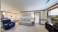 Located at 2581 Bridgewood Rd in Rocky Mount, NC, this well-appointed 2-bedroom, 2-bathroom single-story home offers a comfortable and functional layout with consistent warm wood trim detailing throughout. The living room is a welcoming centerpiece, featuring plush carpeting, crown molding with rich wood accents, and a wood-trimmed fireplace with a raised brick hearth. Built-in shelving flanks the fireplace, adding both character and storage. A door with a window panel allows natural light to filter into the space. Adjacent to the living room, the dining area features hardwood-style flooring, a pendant chandelier, and a cozy atmosphere ideal for everyday meals. The kitchen offers warm wood cabinetry, stainless steel appliances including a refrigerator and range, and a breakfast bar peninsula. Both bedrooms are carpeted and include ceiling fans. The spacious primary bedroom features a walk-in closet, while the second bedroom is well-sized with its own closet access. The bathrooms are clean and functional, with one featuring a wide vanity with wood cabinetry, a large mirror, and tile flooring. A dedicated laundry room provides added convenience. This home combines classic design elements with practical living spaces throughout.