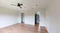 Located at 469 Livingston Ave in Albany, NY, this thoughtfully updated 3-bedroom, 1-bathroom residence offers a clean, modern aesthetic across a single floor. Light-toned hardwood flooring runs throughout the home, creating a bright and cohesive look in every room. Each bedroom is outfitted with a ceiling fan, radiator heating, and black-framed windows that bring in natural light and neighborhood views. The spacious primary bedroom provides generous room for furnishings, while the two additional bedrooms offer comfortable, well-proportioned spaces. The kitchen features white shaker cabinetry, a subway tile backsplash, stone countertops, a deep single-basin sink with a matte black faucet, and a window overlooking the street. The bathroom is a standout with floor-to-ceiling white subway tile, a soaking tub with an overhead rain shower head, matte black fixtures, and a window for natural ventilation. A hallway connects the rooms efficiently within the compact layout. Neutral white walls, clean white trim, and consistent black hardware details throughout give the unit a cohesive, contemporary feel that is move-in ready.