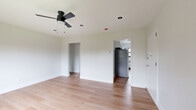 Located at 469 Livingston Ave in Albany, NY, this thoughtfully updated 3-bedroom, 1-bathroom residence offers a clean, modern aesthetic across a single floor. Light-toned hardwood flooring runs throughout the home, creating a bright and cohesive look in every room. Each bedroom is outfitted with a ceiling fan, radiator heating, and black-framed windows that bring in natural light and neighborhood views. The spacious primary bedroom provides generous room for furnishings, while the two additional bedrooms offer comfortable, well-proportioned spaces. The kitchen features white shaker cabinetry, a subway tile backsplash, stone countertops, a deep single-basin sink with a matte black faucet, and a window overlooking the street. The bathroom is a standout with floor-to-ceiling white subway tile, a soaking tub with an overhead rain shower head, matte black fixtures, and a window for natural ventilation. A hallway connects the rooms efficiently within the compact layout. Neutral white walls, clean white trim, and consistent black hardware details throughout give the unit a cohesive, contemporary feel that is move-in ready.