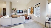 Located at 406 S Boulder Avenue in the heart of downtown Tulsa, this contemporary residence offers a refined urban living experience across a thoughtfully designed single floor. Polished and terrazzo concrete floors run throughout, anchoring the clean, modern aesthetic defined by crisp white walls and high ceilings that amplify the sense of openness.

The kitchen is a standout, featuring floor-to-ceiling matte dark cabinetry, stainless steel appliances, a textured tile backsplash, and a light wood island with seating beneath bold pendant lights. The adjoining living room enjoys soaring ceilings, large black-framed windows with city views, and an open, airy feel. A dedicated dining area is bathed in natural light from expansive windows overlooking the Tulsa skyline.

A long gallery-style hallway connects the main living spaces to the bedrooms, lending an art-forward, editorial atmosphere. The spacious primary bedroom features multiple windows, polished floors, and a ceiling fan, while a second well-proportioned bedroom mirrors the home's bright, minimal character. The primary bathroom is elegantly appointed with a dark-tiled walk-in glass shower, gold fixtures, and a sleek vanity. Two additional bathrooms maintain the same contemporary design language, completing this sophisticated downtown residence.