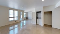This 1-bedroom, 1-bathroom residence is thoughtfully laid out across a single floor, combining modern finishes with functional design. The open living area features gleaming polished concrete floors that reflect natural light pouring in through multiple large windows and a glass-paneled door that leads to an outdoor area, creating a bright and airy atmosphere throughout.

The kitchen is well-appointed with crisp white shaker-style cabinetry extending to the ceiling for ample storage, bold black granite countertops, a stainless steel sink, a dishwasher, and a gas range, forming a clean and efficient L-shaped workspace. A dedicated closet space houses a stacked in-unit washer and dryer, adding everyday convenience.

The bedroom is a calm, neutral space with polished floors, a window dressed with blinds for light control, and clean white walls offering a versatile canvas. The bathroom is spacious and well-equipped, featuring a soaking tub, a separate shower with chrome fixtures, a toilet, and chrome grab bars, all set on polished concrete flooring that complements the rest of the home. The overall aesthetic is clean, modern, and move-in ready.