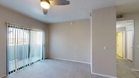 Located at 20401 North 19th Avenue in Phoenix, Arizona, this one-bedroom, one-bathroom unit offers a practical and well-organized single-floor layout. The living room is a bright, open space featuring plush carpeting, a ceiling fan with light fixture, and a sliding glass door dressed with vertical blinds that invites natural light and provides outdoor access. The entry area transitions from wood-look flooring to carpet, creating a clear distinction between zones. The kitchen is a standout feature, boasting white shaker-style cabinetry, dark countertops, a tile backsplash, wood-look flooring, and black appliances including a full-size refrigerator. Track lighting above illuminates the efficient U-shaped layout, which includes a sink and ample cabinet storage. The bedroom is a comfortable, carpeted retreat with a window allowing in natural light and a door leading to the hallway and closet. The bathroom features wood-look flooring, white cabinetry with a dark countertop, a single-basin sink, a large mirror, and grab bars along the walls. A dedicated closet and hallway complete the functional floor plan, making this unit a well-appointed and efficiently designed space in the heart of Phoenix.