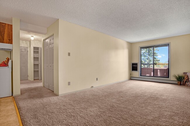 A large living room with window overlooking the property - Cedarcrest Manor