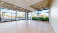 This two-story residence on E Colfax Ave in Aurora, Colorado offers a thoughtfully designed layout spread across two generous floors. The main level immediately impresses with its dramatic floor-to-ceiling glass windows that wrap around the living area, flooding the space with natural light and framing sweeping outdoor views. Exposed concrete ceiling accents complement the light hardwood flooring, lending a contemporary, industrial-modern aesthetic throughout.

The open-concept kitchen and living area on the main floor features a sleek kitchen equipped with stainless steel appliances, a built-in microwave, a stainless refrigerator, and rich wood cabinetry paired with clean white countertops and a subway tile backsplash. A large central island anchors the space, ideal for both cooking and casual dining.

The upper floor hosts three bedrooms, including a well-proportioned primary bedroom with a ceiling fan, large windows, and direct access to a private balcony. Bedrooms are finished with plush carpeting, while closets include built-in wire shelving for organized storage. The bathrooms are clean and modern, with one featuring accessibility-conscious grab bars. A staircase and hallway connect both levels seamlessly, completing this well-appointed, light-filled home.