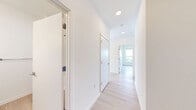 This thoughtfully designed 2-bedroom, 2-bathroom residence at 1625 Lock Ln in Madison, WI offers a contemporary living experience defined by clean lines, neutral tones, and abundant natural light. Light wood-style flooring flows throughout, tying the space together with a warm, cohesive aesthetic.

The open-concept kitchen is a standout feature, showcasing a large island with a built-in sink, light wood cabinetry, white upper cabinets, quartz-style countertops, and stainless steel appliances — all illuminated by a sleek linear pendant light. A large window fills the kitchen with natural light and greenery views.

The living area is bright and airy, lined with multiple tall windows and sliding glass doors that open to a private balcony overlooking the surrounding neighborhood and treetops. Both bedrooms are well-proportioned and sun-filled, each featuring a ceiling fan and large windows with outdoor views. The primary bedroom includes a generous double-door closet for ample storage.

The two bathrooms are finished in a clean, modern style — one featuring a glass-enclosed walk-in shower with warm wood-tone vanity, and the other offering a full soaking tub with shower combo in an all-white surround. The overall ambiance is light, fresh, and move-in ready.