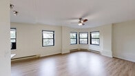 Located on Chicago's prestigious North Lake Shore Drive in the Gold Coast neighborhood, this three-bedroom, one-bathroom residence offers a well-organized layout across a single floor. Light hardwood flooring flows throughout the space, creating a cohesive and bright interior complemented by crisp white walls.

The combined kitchen and living area serves as the heart of the home. The kitchen is outfitted with rich, dark espresso cabinetry, granite-style countertops, stainless steel appliances including a gas range, microwave, and refrigerator, and a peninsula that provides additional prep space and casual seating. The adjacent living area benefits from multiple windows that invite natural light and neighborhood views.

The generously sized primary bedroom offers ample room for comfortable furnishings, with windows providing outdoor views and a ceiling fan overhead. The two additional bedrooms are well-proportioned, each featuring hardwood floors, windows, and baseboard heating. A dedicated closet with wire shelving provides practical storage.

The full bathroom features floor-to-ceiling neutral tile, a frameless glass-enclosed walk-in shower, a pedestal sink, and classic mosaic tile flooring. A hallway connects the rooms efficiently, contributing to the overall functional flow of the residence.