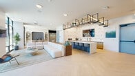 Located at 1301 Lebanon Pike in Nashville, TN, this single-floor amenity space offers a thoughtfully designed communal environment spanning a generous footprint. The open-plan main lounge is anchored by light herringbone hardwood flooring, crisp white walls, and an abundance of natural light streaming through expansive floor-to-ceiling steel-framed windows that overlook an outdoor courtyard with seating and umbrellas. A central wet bar and island with bar seating serves as a social hub, accented by a bold geometric patterned feature wall and a suspended metal open-shelf display above. A cozy lounge nook features a tufted velvet sofa, arched built-in shelving styled with plants and books, wood beam ceiling details, and a sleek recessed fireplace — creating an intimate retreat within the larger space. A dedicated golf simulator room is equipped with a Trackman system, projection screen, and turf flooring, complemented by a comfortable seating area for spectators. The hallway connects the various areas seamlessly, maintaining the space's clean, modern aesthetic throughout. Overall, the design blends contemporary minimalism with warm textures and curated décor, making it an inviting and versatile gathering destination.