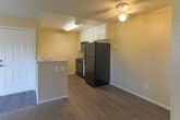 Located at 23215 Ironwood Ave, Unit 5 in Moreno Valley, California, this single-floor residence offers a straightforward and functional layout suited for comfortable everyday living. The kitchen is efficiently designed with white cabinetry, speckled laminate countertops, a double stainless steel sink, and black appliances including a gas range and overhead microwave, all set atop durable wood-look flooring. The living area is carpeted and bathed in natural light streaming through a sliding glass door that opens to a private balcony with outdoor views, creating a welcoming and airy atmosphere. Warm beige walls and a textured ceiling are consistent throughout the space, lending a cohesive and neutral aesthetic. The bedroom is a quiet, well-proportioned room featuring plush carpeting, a window with views of the surrounding greenery, and a textured ceiling. The bathroom is clean and practical, equipped with a full-size soaking tub and shower combo, a white vanity with matching speckled countertop, and wood-look flooring that ties in with the kitchen. Overall, this unit presents a clean, move-in ready space with a consistent design palette and practical amenities throughout.