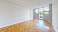Located at 24 Mabelle Ave in Toronto's Etobicoke neighbourhood, this one-bedroom, one-bathroom unit offers a thoughtfully organized layout across a single floor. Warm parquet flooring runs throughout the living room, bedroom, and entry hallway, lending a classic character to the space. The living room is the heart of the unit, bathed in natural light through large floor-to-ceiling windows and a sliding glass door that opens onto a private balcony with open views of the surrounding cityscape and greenery. The galley-style kitchen is efficiently designed with white cabinetry featuring brushed gold hardware, granite-look countertops, a double sink, and white appliances, all set on clean white tile flooring. The bedroom offers a comfortable footprint with a large window framing outdoor views, built-in closet storage, and the same warm parquet flooring found throughout. The bathroom is finished with full-surround white tile and a soaker tub with chrome fixtures, maintaining a clean and neutral aesthetic. A textured ceiling is consistent throughout the unit. The overall ambiance is bright, clean, and functional, well-suited for those seeking a practical urban residence in Toronto.