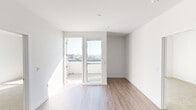 This thoughtfully designed single-floor residence showcases a clean, contemporary aesthetic throughout, characterized by crisp white walls, wood-look flooring in the main living areas, and an abundance of natural light. The open kitchen is a standout feature, outfitted with stainless steel appliances including a range, microwave, and refrigerator, complemented by a two-tone cabinet design pairing light wood lower cabinets with sleek grey upper cabinetry. A tile backsplash and white quartz countertops complete the modern look. The living area flows naturally toward a private balcony accessible through a glass-panel door, offering sweeping elevated city views that fill the space with light and openness. The bedrooms feature plush carpeting and large windows framing panoramic urban vistas, including palm tree-lined streets below — suggestive of a Southern California setting. One bedroom connects directly to a full bathroom, which includes a soaking tub with tile surround, wood-toned vanity, and white quartz countertop. A second bathroom offers matching finishes and a similarly clean, minimal design. The overall ambiance is bright, fresh, and modern, making excellent use of natural light and elevated positioning to create an airy, well-connected living environment.