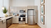 Located at 30 Market St SW in the heart of downtown Concord, NC, this one-bedroom, one-bathroom residence offers a thoughtfully designed layout with contemporary finishes throughout. The open-concept kitchen and living area serves as the centerpiece of the home, featuring warm wood-look flooring that flows seamlessly through the main living spaces. The kitchen is equipped with stainless steel appliances, light wood cabinetry, granite countertops, a peninsula with pendant lighting, and a built-in sink — ideal for both everyday cooking and casual dining. The living room is bright and inviting, bathed in natural light from large windows with views of the surrounding downtown cityscape. Neutral toned walls and clean lines create a calm, modern ambiance throughout. The bedroom offers plush carpeting, a dedicated closet, and a window framing urban views, providing a comfortable and quiet retreat. The bathroom is finished with wood-grain cabinetry, granite countertops, a large mirror, and a full tub-shower combination with subway tile surround and wood-look flooring. A dedicated closet adds practical storage to complement the efficient and functional floor plan of this centrally located residence.