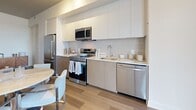 Located at 815 Avenue Plymouth in Mont-Royal, Quebec, this modern two-bedroom, two-bathroom residence offers a thoughtfully designed open-concept layout finished with contemporary details throughout. Light-toned hardwood flooring flows seamlessly across the single level, lending warmth and continuity to each room.

The kitchen is well-appointed with stainless steel appliances, including a refrigerator, electric range, over-the-range microwave, and dishwasher. Crisp white upper cabinetry contrasts elegantly with the two-toned lower cabinets, while a classic subway tile backsplash and light quartz countertops complete the clean, modern aesthetic. The kitchen opens directly to the dining area and living room, creating a cohesive and sociable space. Large windows in the living room fill the area with natural light and offer expansive outdoor views.

The primary bedroom is a comfortable retreat with a generous footprint, featuring a large window with outdoor views and direct access to a well-appointed bathroom complete with a glass-enclosed walk-in shower and marble-style tile flooring. The second bedroom is bright and clean, highlighted by light walls and hardwood floors. Two closets provide practical storage throughout the unit. A welcoming hallway connects all areas of the residence, rounding out this well-planned and stylish home.
