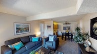 Located at 13102 E Kansas Drive in Aurora, Colorado, this single-floor residence offers a practical and well-organized layout suited for everyday living. The living room serves as the central gathering space, featuring wall-to-wall carpeting, a textured ceiling, and a sliding glass door that opens to an outdoor patio, allowing natural light to fill the room. Exposed ceiling beams add a subtle architectural detail to the space.

Adjacent to the living area, the dining space accommodates a full dining set and is finished with a ceiling fan and light fixture overhead. A built-in shelving unit provides convenient additional storage nearby. The galley-style kitchen is efficiently designed with warm wood cabinetry, dark granite-style countertops, tile flooring, and white appliances including a range, microwave, refrigerator, and dishwasher.

The bedrooms are carpeted and receive natural light through windows dressed with sheer curtains. Each room offers a comfortable, functional layout. The bathroom includes a full tub and shower combination with tile surround, while a second bathroom features a single vanity with a mirrored medicine cabinet and overhead lighting. Throughout the residence, a neutral color palette creates a cohesive and inviting atmosphere.