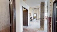 Located at 819–843 First Ave N in Moorhead, MN, this three-bedroom, three-bathroom industrial loft offers a compelling blend of raw, historic character and modern functionality. The unit spans a generous single floor, with a layout that includes a kitchen, living room, three bedrooms, three bathrooms, and an in-unit laundry room.

Original brick flooring runs throughout much of the space, lending a warm, textured aesthetic that echoes the building's industrial heritage. Exposed brick walls, visible structural columns, and overhead piping add to the loft's authentic character, while soaring ceilings—particularly prominent in the kitchen and bedroom areas—create an expansive sense of volume.

The kitchen features warm wood cabinetry, stainless steel appliances, and track lighting beneath a high ceiling, with room for a dining table. The spacious living room showcases a large multi-pane window that floods the space with natural light and frames exterior views, complemented by a wall-mounted mini-split HVAC system. Each bedroom offers generous proportions, with the primary bedroom providing ample space and natural light through large windows. The bathrooms include wood-toned vanities with modern fixtures, and at least one features a dedicated shower stall. The dedicated laundry room houses a full-size washer and dryer with built-in shelving.