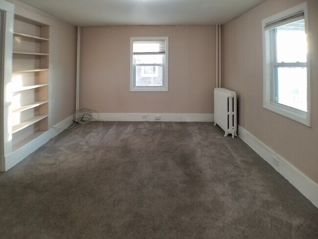 View of large living room from kitchen. Built-in bookshelf on the left. - 7 S Hillside Ave