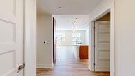 This single-floor residence in Ellicott City, Maryland, offers a thoughtfully designed layout with three bedrooms, two bathrooms, and a dedicated laundry room. The open-concept kitchen and living area serves as the heart of the home, featuring light hardwood-style flooring that flows throughout the main spaces. The kitchen is well-equipped with warm maple cabinetry, granite countertops with subtle grey veining, a subway tile backsplash, stainless steel appliances including a range, microwave, and refrigerator, and a central island with a undermount sink—pendant lighting above completes the space. Natural light filters in through multiple windows, lending a bright, airy quality to the living area.

The primary bedroom is generously sized and includes a walk-in closet outfitted with wire shelving systems for organized storage. Additional bedrooms feature light hardwood-style flooring or plush carpet, with windows providing natural light. Both bathrooms include granite-topped wood vanities and light wood-style flooring. The dedicated laundry room houses a full-size Whirlpool washer and dryer with overhead wire shelving. Neutral wall tones and clean finishes throughout give the space a modern, move-in-ready appeal.