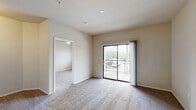 Located at 1400 E University Dr in Denton, TX, this one-bedroom, two-bathroom unit offers a thoughtfully arranged single-floor layout. The living area is carpeted and bathed in natural light from a sliding glass door that opens to a private balcony, providing outdoor views of the surrounding area. A half-wall pass-through connects the living space to the galley-style kitchen, which features warm honey-toned wood cabinetry, a double-basin sink, laminate wood-look flooring, and white appliances including a refrigerator, range, and dishwasher. The open layout between the living room and kitchen creates a functional, connected flow throughout the common areas. The bedroom is a comfortable size, complete with plush carpeting, a ceiling fan, a bright window with blinds, and direct access to a private bathroom. Two closets provide ample storage throughout the unit. The bathrooms include a full tub-and-shower combination with white tile surround, wood-look flooring, a vanity with countertop, and accessible grab bars. Neutral warm-toned walls throughout the unit create a clean, versatile backdrop. The unit's efficient design makes excellent use of its footprint, offering practicality and comfort in a convenient Denton location.