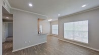 Located at 3787 Perrin Central Blvd in San Antonio, Texas, this single-story residence offers a clean, modern interior with a thoughtfully designed layout. The open living and dining area features wood-look plank flooring, neutral gray walls, crown molding, and recessed lighting, creating a bright and welcoming atmosphere. Large windows fitted with blinds allow abundant natural light to fill the space throughout the day.

The kitchen is equipped with dark cabinetry, granite-look countertops, a stainless steel sink with a flexible faucet, and stainless steel appliances including a refrigerator, microwave, and range. A pass-through counter connects the kitchen to the living area, enhancing the open-concept feel.

The bedrooms are carpeted for comfort and include ceiling fan fixtures and windows that bring in natural light. Closet storage is also available within the bedroom areas.

The bathrooms feature a tub-shower combination with white tile surround, granite-top vanities, and dark cabinetry — one bathroom showcasing a bold blue vanity as a standout design element. Wood-look flooring completes the bathroom spaces.

The entry area offers a welcoming foyer with plank flooring and recessed lighting, setting the tone for the well-maintained interior found throughout this San Antonio residence.