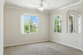 Located at 39415 Ardenwood Way in Lake Elsinore, CA, this single-story, one-bedroom, one-bathroom home offers a well-planned layout across a comfortable footprint. The living and dining area is bright and open, featuring plush carpet, crown molding, a ceiling fan, and multiple windows that invite natural light and views of surrounding greenery. Elegant arched doorways connect the living space to the rest of the home, adding a refined architectural touch throughout.

The kitchen is efficiently designed with warm wood-toned cabinetry, white countertops, and black appliances including a range, microwave, and full-size refrigerator. Light hardwood-style flooring runs through the kitchen, which flows directly into a dedicated laundry area with a stacked washer and dryer.

The bedroom is a well-proportioned retreat featuring carpet flooring, a ceiling fan, and a window overlooking lush outdoor foliage. An adjacent walk-in closet provides generous storage with wire shelving on multiple walls. The bathroom is clean and functional, offering a wood-toned vanity with white countertop, a large mirror with overhead lighting, and a full shower-tub combination. A private patio completes this home, offering an outdoor extension of the living space.