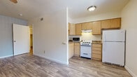 Located at 620 N Litchfield Rd in Goodyear, Arizona, this single-floor unit offers a clean, functional layout with a consistent design language throughout. Wood-look plank flooring flows seamlessly across every room, providing a warm and cohesive aesthetic.

The kitchen is efficiently laid out and features light maple-toned cabinetry with ample upper and lower storage, granite-look countertops, a gas range, built-in microwave, and a full-size refrigerator. The open adjacency to the living area enhances the sense of space and connectivity.

The living and bedroom areas are well-proportioned, each equipped with ceiling fans for added comfort. Neutral white walls and updated flooring keep the spaces feeling bright and move-in ready. Several rooms feature windows dressed with vertical or horizontal blinds, allowing for natural light while maintaining privacy. One room showcases a painted brick accent wall, adding a subtle architectural detail.

The bathroom includes a light wood vanity with a granite-look countertop, an integrated sink, and a large mirror with overhead lighting. An adjacent walk-in closet area with built-in shelving provides generous storage. A secondary water closet with its own access adds additional convenience. The overall ambiance is clean, neutral, and well-maintained, making it a practical and comfortable space.
