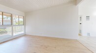 Located at 4143 Palmwood Dr in Los Angeles, CA, this compact yet well-designed single-floor, one-bedroom, one-bathroom unit makes efficient use of its space across six distinct rooms. The interior is characterized by a clean, bright aesthetic throughout, with crisp white walls and an abundance of natural light.

The living room and bedroom feature light wood laminate flooring and distinctive white beamed ceilings that add architectural character and a sense of height. Large windows in multiple rooms frame outdoor greenery and invite ample sunlight throughout the day. The bedroom includes a mirrored sliding closet and direct access to the hallway leading to the bathroom.

The kitchen is well-equipped with white cabinetry, light-toned countertops, a stainless steel gas range, and a full-size refrigerator. Light ceramic tile flooring runs through the kitchen, dining area, and hallway, providing a practical and cohesive transition between spaces. The dining area features large windows with views to the outside and a wall sconce for added lighting.

The bathroom is finished in white with a full-size bathtub and tiled surround, complemented by a window for natural ventilation. A connecting hallway with a wall sconce and built-in vents links all areas seamlessly, completing this functional and airy Los Angeles residence.