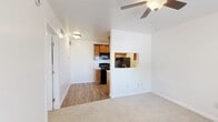 Located at 1130 W Saint Mary's Rd in Tucson, Arizona, this efficiently designed one-bedroom, one-bathroom unit makes smart use of its compact footprint. The open-concept layout seamlessly connects the living room, dining area, and kitchen, creating a cohesive and functional living space. Wood-look flooring runs throughout the kitchen and main living areas, while plush carpet adds warmth to the living room and bedroom.

The galley-style kitchen is well-appointed with warm honey-toned cabinetry, marble-look countertops, a stainless steel sink, and a full suite of black appliances including a refrigerator, electric range, and built-in microwave. A pass-through window connects the kitchen to the living area, enhancing the open feel. A ceiling fan in the living room provides added comfort.

The bedroom is a quiet retreat, featuring soft carpet, a ceiling fan, and a window with natural light and outdoor views. It offers direct access to both the bathroom and a dedicated closet. The bathroom is neatly finished with warm wood cabinetry, a marble-look countertop, dual framed mirrors, and a window that brings in additional natural light. Clean white walls throughout the unit create a bright, airy ambiance.