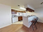 This single-story, 2-bedroom, 1-bathroom unit at Eagle Crest in Waco, Texas offers a practical and comfortable layout designed to maximize functionality. The kitchen is a standout feature, equipped with rich dark wood cabinetry, granite-style countertops, white appliances including a dishwasher and refrigerator, and tile flooring. A peninsula-style breakfast bar with bar seating extends into the adjoining living area, creating an open, connected feel that encourages casual dining and easy entertaining. The living and dining areas feature warm wood-look laminate flooring, contributing to a cohesive and inviting atmosphere throughout the common spaces.

Both bedrooms are bright and neutrally finished with light-toned tile flooring, white walls, and windows fitted with blinds that allow for natural light control. The rooms offer a clean, versatile canvas well-suited for a variety of furniture arrangements. A ceiling fan is present in one of the bedrooms, adding comfort and airflow.

The single full bathroom features a white vanity with granite-style countertops, a large mirror, tile flooring, and a shower-tub combination with a curtain enclosure, maintaining a clean and functional aesthetic throughout. Textured ceilings are consistent across the unit, adding a subtle architectural detail to each room.