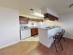 This single-story, 2-bedroom, 1-bathroom unit at Eagle Crest in Waco, Texas offers a practical and comfortable layout designed to maximize functionality. The kitchen is a standout feature, equipped with rich dark wood cabinetry, granite-style countertops, white appliances including a dishwasher and refrigerator, and tile flooring. A peninsula-style breakfast bar with bar seating extends into the adjoining living area, creating an open, connected feel that encourages casual dining and easy entertaining. The living and dining areas feature warm wood-look laminate flooring, contributing to a cohesive and inviting atmosphere throughout the common spaces.

Both bedrooms are bright and neutrally finished with light-toned tile flooring, white walls, and windows fitted with blinds that allow for natural light control. The rooms offer a clean, versatile canvas well-suited for a variety of furniture arrangements. A ceiling fan is present in one of the bedrooms, adding comfort and airflow.

The single full bathroom features a white vanity with granite-style countertops, a large mirror, tile flooring, and a shower-tub combination with a curtain enclosure, maintaining a clean and functional aesthetic throughout. Textured ceilings are consistent across the unit, adding a subtle architectural detail to each room.