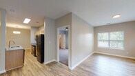 Located at 2320 Grinstead Dr in Louisville, Kentucky, this two-bedroom, two-bathroom residence offers a well-designed single-floor layout with a cohesive blend of comfort and functionality. The open-concept living and dining area is finished with light hardwood-style flooring and neutral warm-gray walls, creating a bright and welcoming atmosphere. Multiple windows along the living room wall flood the space with natural light and offer views of the surrounding greenery. A modern pendant light fixture highlights the dedicated dining area, which flows seamlessly into the kitchen. The kitchen features light maple cabinetry, granite-style countertops, a peninsula with a built-in sink, and black appliances including a refrigerator, range, and built-in microwave. Both bedrooms are carpeted for comfort and equipped with ceiling fans. The primary bedroom includes a walk-in closet with built-in shelving. The second bedroom is generously sized with a window and ceiling fan. Both bathrooms are appointed with wood-toned vanity cabinetry, granite countertops, hardwood-style flooring, and full tub/shower combinations. The overall design is clean and practical, suited for everyday living in a convenient Louisville location.