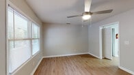 This single-story residence at Lexington Heights offers a practical and cohesive layout throughout. Consistent wood-look flooring runs through the living areas and bedrooms, complemented by neutral gray walls and crisp white baseboards that create a clean, understated aesthetic.

The living area is generously proportioned, featuring a ceiling fan with integrated lighting and open sightlines that connect to adjacent rooms. Multiple bedrooms are present, each fitted with windows dressed in horizontal blinds that allow natural light while maintaining privacy. Several rooms also include ceiling fans, contributing to comfortable climate control throughout.

The kitchen is a functional highlight, featuring an L-shaped layout with rich dark cabinetry, light countertops, and black appliances including a range, dishwasher, and refrigerator. A double-basin sink sits beneath a window, and a door provides direct exterior access. An adjacent utility area accommodates a washer and dryer, adding in-unit convenience.

The bathroom includes a full tub-shower combination with white surround, a dark-cabinet vanity with light countertop, and tile flooring. Overall, the space presents a well-maintained, move-in-ready environment with functional features suited for everyday living.