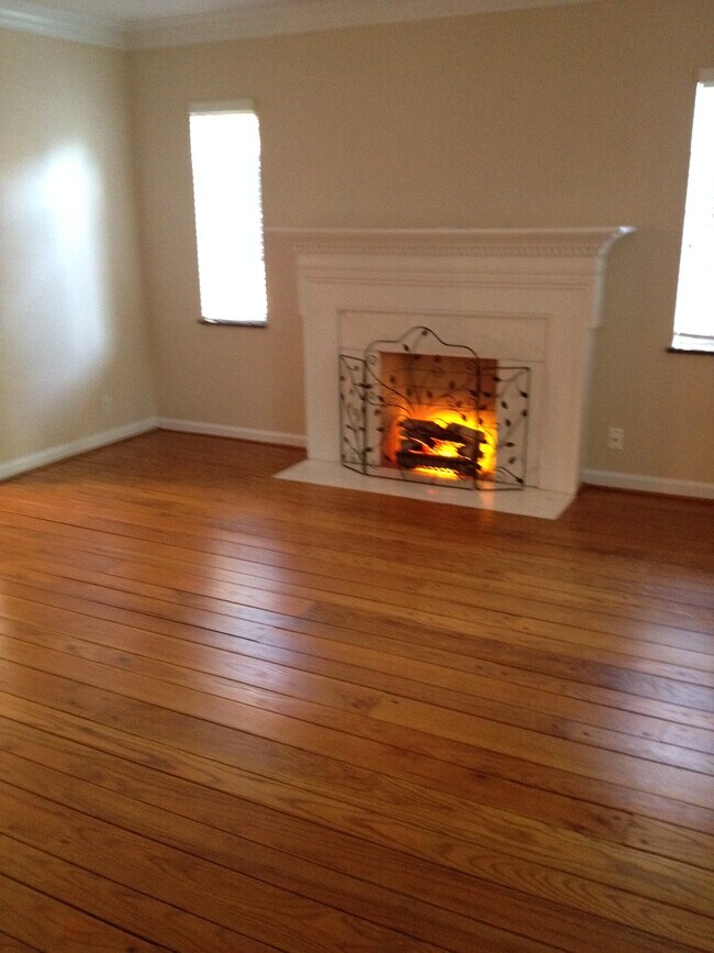 Living room has electric fireplace and beautiful hardwood floors. - 3524 Telford St