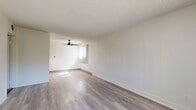 Located at 13200 Bromont Ave in Los Angeles, CA, this 1-bedroom, 1-bathroom unit offers a thoughtfully laid-out single-floor design. The open living area is bright and inviting, featuring light gray hardwood-style flooring, neutral white walls, a textured ceiling, and a ceiling fan. Large windows allow natural light to fill the space while offering pleasant outdoor views of surrounding greenery. The combined kitchen and living room layout maximizes functionality, with the kitchen showcasing warm honey-toned wood cabinetry, gray countertops, stainless steel appliances including an electric range and refrigerator, and a double stainless steel sink. The bedroom is a comfortable, carpeted retreat equipped with a ceiling fan, a spacious built-in closet with panel doors, and a window with garden views, adding a serene touch. The bathroom is clean and functional, featuring a tub/shower combo with chrome fixtures and wood-style flooring that ties back to the main living areas. Throughout the unit, the consistent use of neutral tones and modern finishes creates a cohesive, move-in-ready atmosphere ideal for comfortable everyday living.