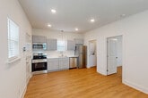 Located at 2501 Brightside Dr in Baton Rouge, Louisiana, this well-designed one-bedroom, one-bathroom unit offers a smart, efficient layout across a single floor. Light-toned hardwood-style flooring runs throughout, creating a cohesive and clean aesthetic that brightens the entire space.

The open-concept main area seamlessly integrates the kitchen, dining, and living spaces. The kitchen is a standout feature, outfitted with gray shaker-style cabinetry, white countertops, and a full suite of stainless steel appliances including a refrigerator, electric range, microwave, and dishwasher. A pendant light above the sink and recessed ceiling lights provide layered illumination, while multiple windows with blinds invite natural light.

A dedicated laundry area with a stacked washer and dryer adds everyday convenience. The bedroom is a comfortable, well-proportioned retreat featuring a ceiling fan with light fixture, a window with blinds, and a wall-mounted HVAC unit. A closet provides additional storage. The bathroom includes a full tub-shower combination with a curved curtain rod, a toilet, and an overhead cabinet for storage. Clean white walls and warm flooring continue throughout, giving the entire unit a bright, move-in-ready feel.