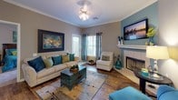 Located at 118 Barrington Dr in Bossier City, Louisiana, this single-story home offers a well-appointed layout designed for comfortable everyday living. The living room serves as a welcoming centerpiece, featuring a tiled fireplace, hardwood-style flooring, crown molding, and natural light from plantation-shuttered windows. A ceiling fan adds practicality, while the teal and neutral color palette creates a cohesive, inviting atmosphere. Adjacent to the living area, the dining room makes a bold statement with a rich terracotta accent wall, crown molding, and pendant lighting overhead — an ideal space for entertaining. The galley-style kitchen is efficiently designed with light wood cabinetry, ample counter space, white appliances, a double sink, and durable hardwood-style flooring, along with a convenient louvered-door pantry. The home includes multiple bedrooms, each finished with neutral tones, ceiling fans, and generous natural light from multiple windows. The primary bedroom features plush carpeting and dark wood furniture accents. Two full bathrooms are present, each equipped with a tub-shower combination, vanity with storage, and hardwood-style flooring — offering functional and clean spaces throughout.