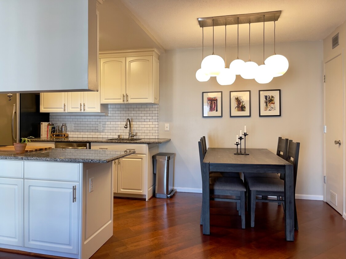 Open kitchen with stunning West Elm light fixture in dining space. - 2262 Benson Ave