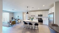 Located at 2120 NW Lowenstein Dr in Lee's Summit, Missouri, this single-floor residence presents a cohesive modern design throughout. The open-concept living area anchors the layout, where the kitchen, dining, and living spaces flow seamlessly together. The kitchen is outfitted with white shaker cabinetry extending to the ceiling for maximum storage, a white countertop island with bar seating, stainless steel appliances including a range, microwave, dishwasher, and refrigerator, and a classic subway tile backsplash. A bold pendant light serves as a focal point above the island. Light wood-tone flooring runs throughout the main living areas, lending warmth and continuity to the space. The living room opens to a private balcony through sliding glass doors, offering unobstructed outdoor views. Bedrooms are bright and well-proportioned, each benefiting from natural light through blinds-fitted windows. A dedicated flex room provides versatile space suitable for a home office or sitting area. The bathroom features a dual-sink vanity with white cabinetry, a large mirror, and a walk-in shower. A wide hallway with ample closet storage completes this well-designed residence.