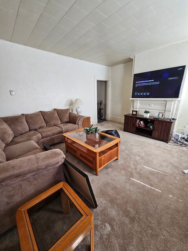 Living room furnished with couch, TV stand, coffee table, and end table - 314 Hays Ave