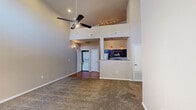 Located at 1335 Pullman Dr in El Paso, TX, this 1-bedroom, 1-bathroom home makes a strong first impression with its dramatic vaulted ceilings that lend an open, airy feel well beyond its modest footprint. The living room is anchored by a ceiling fan and soft carpeting, with a front entry door flanked by a window that draws in natural light. A raised-ceiling architectural detail with track lighting adds visual interest above the kitchen pass-through area.

The kitchen is well-appointed with rich dark cabinetry, light stone-look countertops, hardwood-style flooring, and stainless steel appliances including a gas range and full-size refrigerator. A pantry with built-in shelving sits just off the kitchen, offering convenient additional storage. An in-unit stackable washer and dryer is also tucked nearby.

The bedroom is a comfortable, carpeted retreat with tall ceilings, a large window overlooking the exterior, and direct access to the bathroom and a dedicated walk-in closet outfitted with hanging rods and shelving. The bathroom features clean tile flooring and a tub-shower combination. Neutral tones throughout the home provide a versatile canvas adaptable to a range of personal styles.